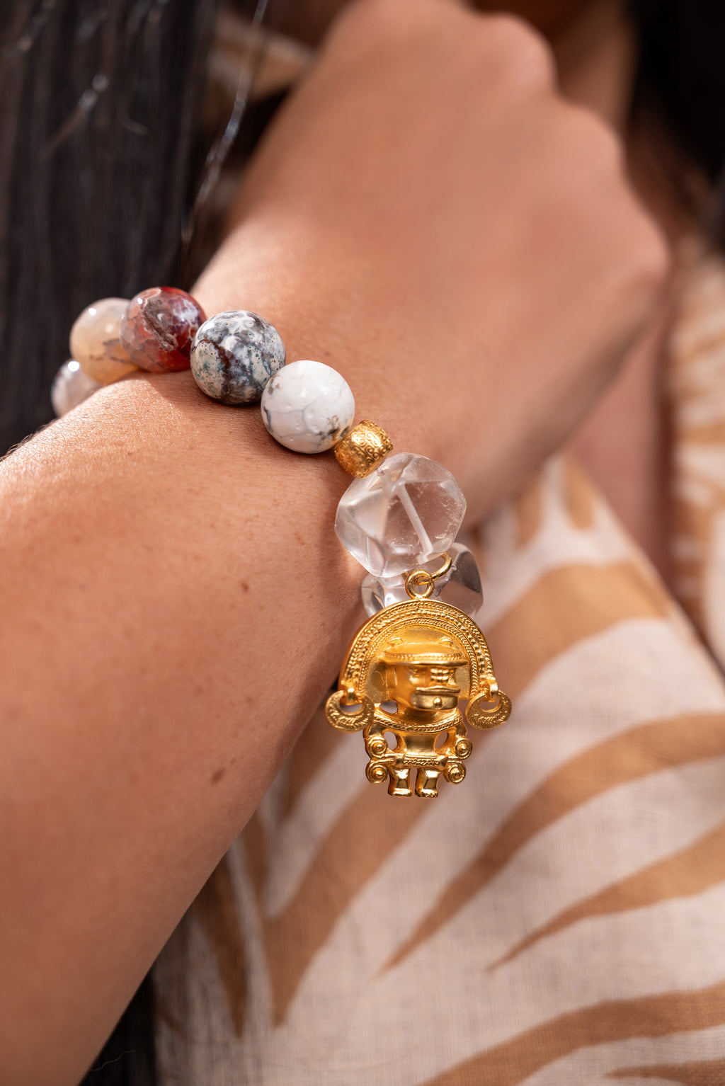 Woman wearing agate and quartz gemstones bracelet with 24k gold plated charm