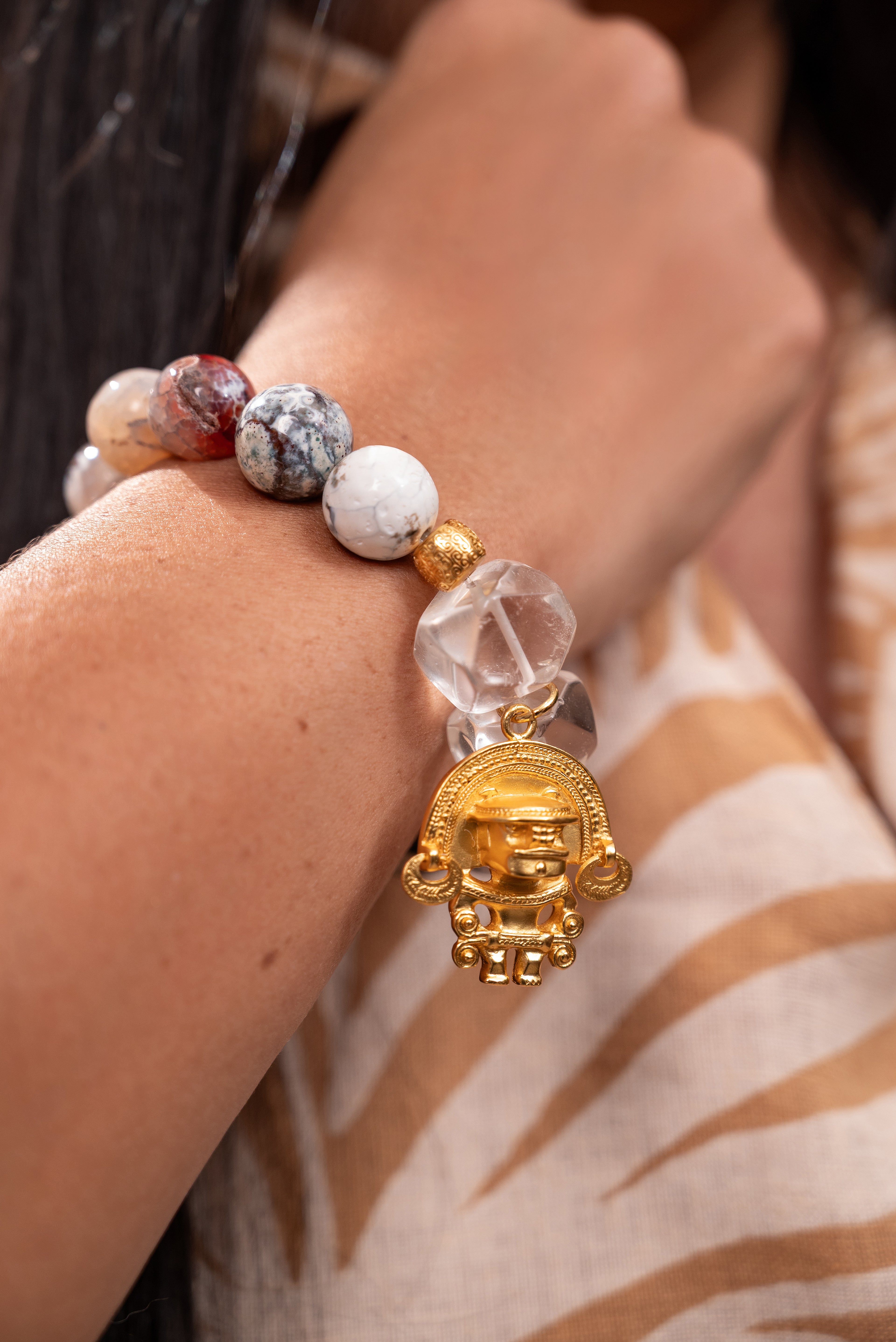 Woman wearing agate and quartz gemstones bracelet with 24k gold plated charm