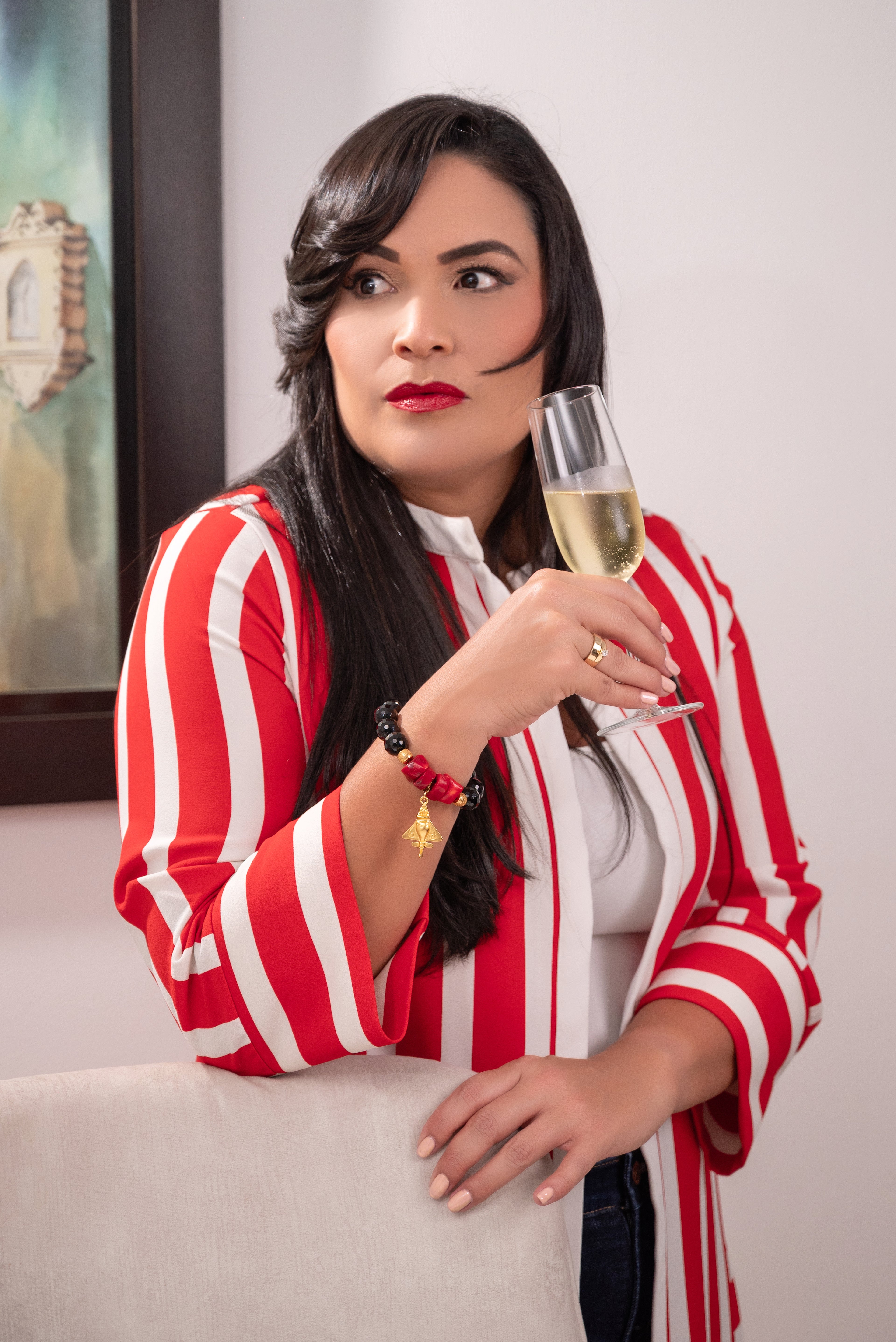 Frau trägt Edelsteinarmband aus Onyx und Korallen mit 24K Gold Anhänger und vergoldeten Sterling Silver Elementen